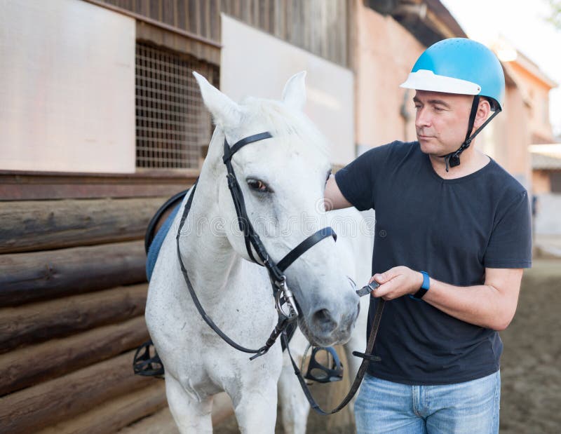mature-smiling-man-farmer-helmet-standing-white-horse-stable-outdoor-mature-smiling-man-farmer-helmet-standing-198465812